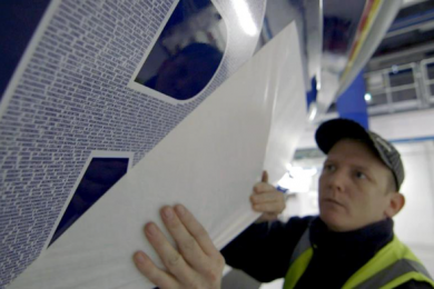 Names going on to the side of a lifeboat Worker placing names on the side of a lifeboat