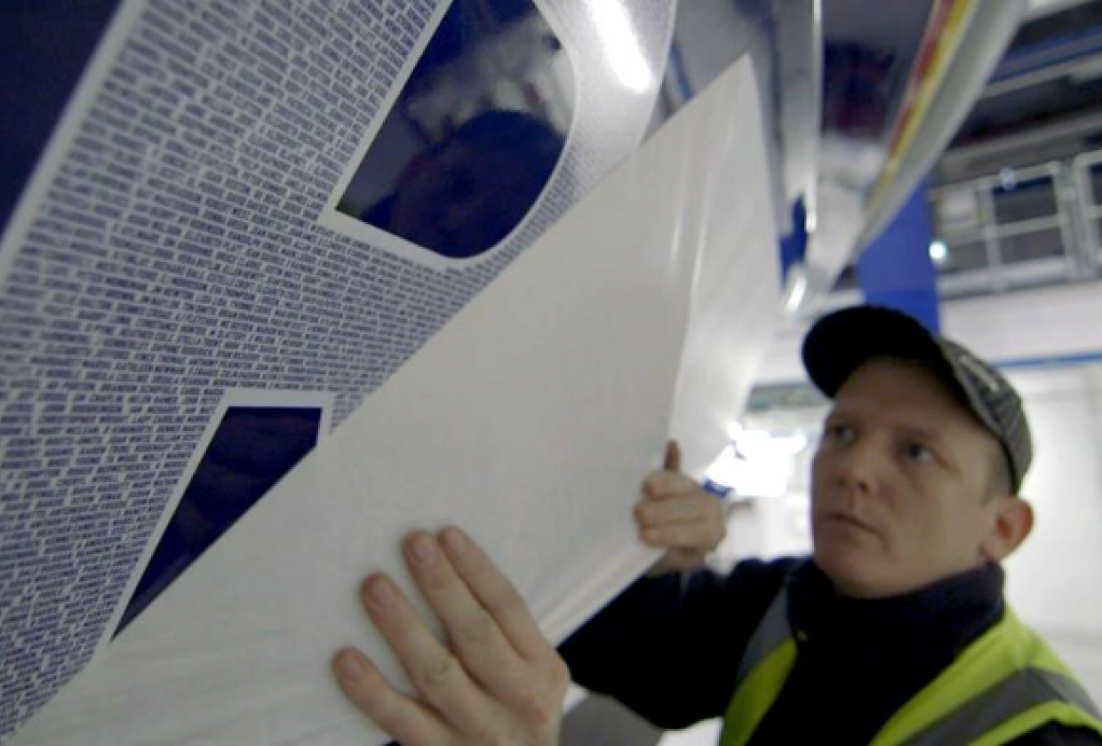 Worker placing names on the side of a lifeboat
